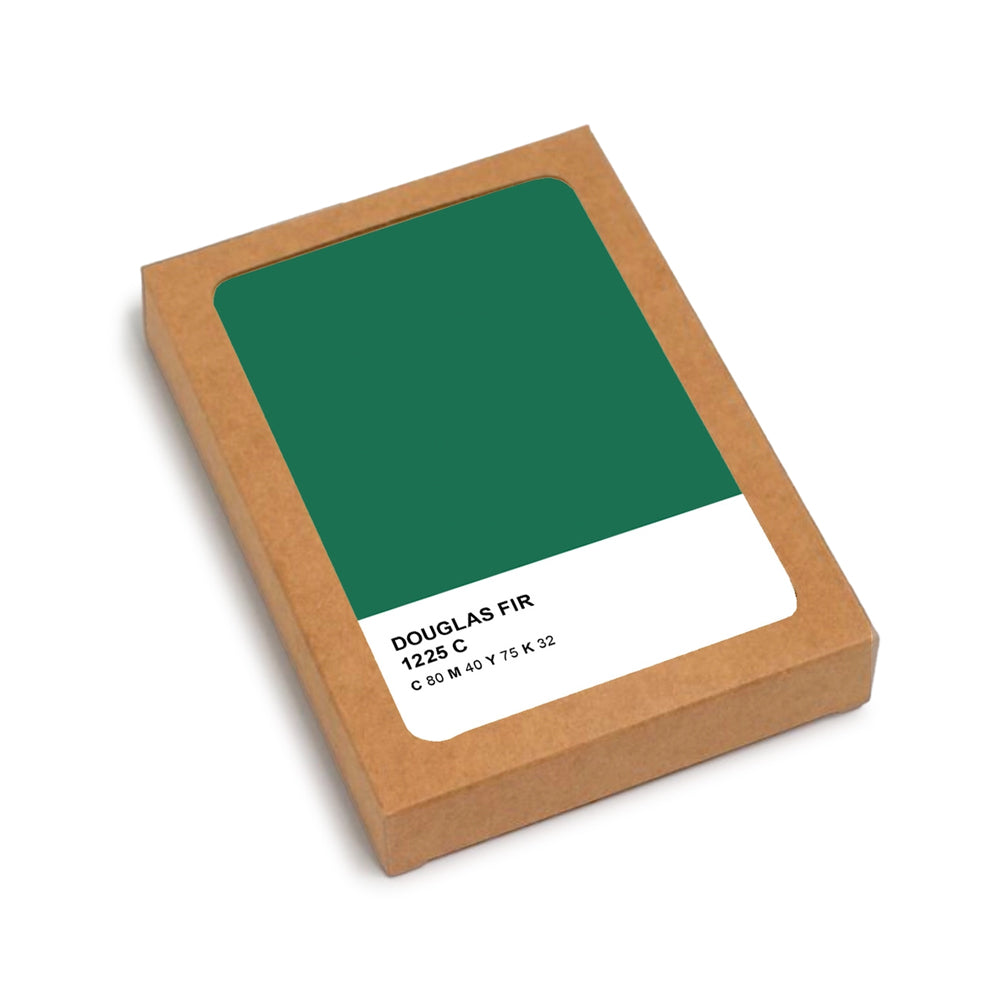A Douglas Fir wood color swatch card in its original kraft paper packaging, showing a deep green color sample labeled 'DOUGLAS FIR 1225 C'.
