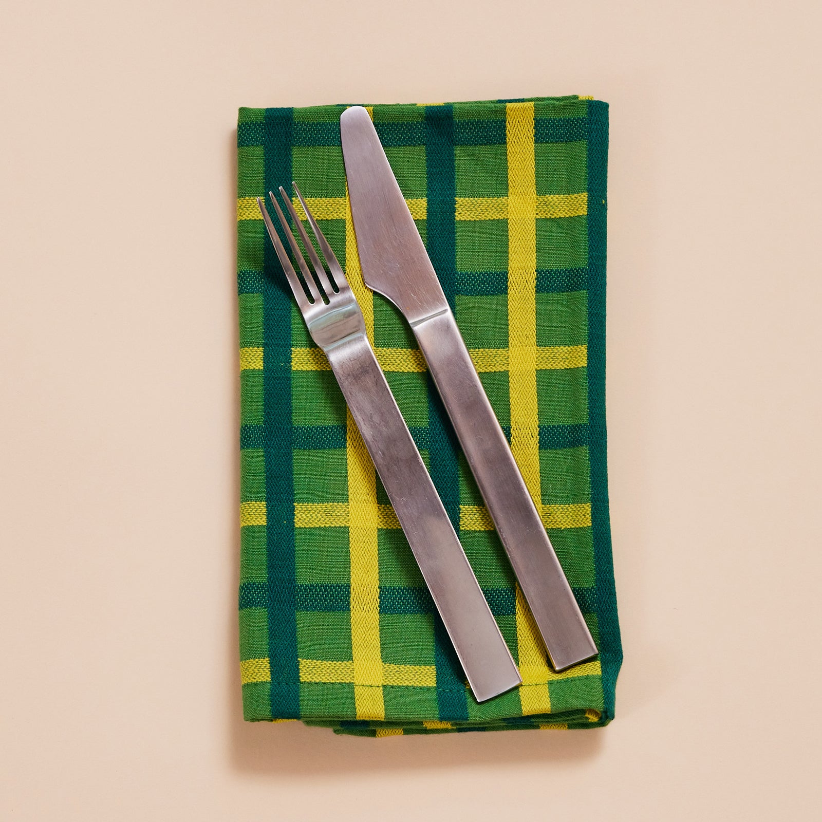 Four colorful plaid napkins on a white background