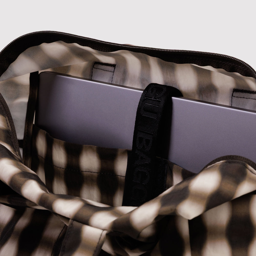 Laptop in a patterned bag with a visible brand logo.