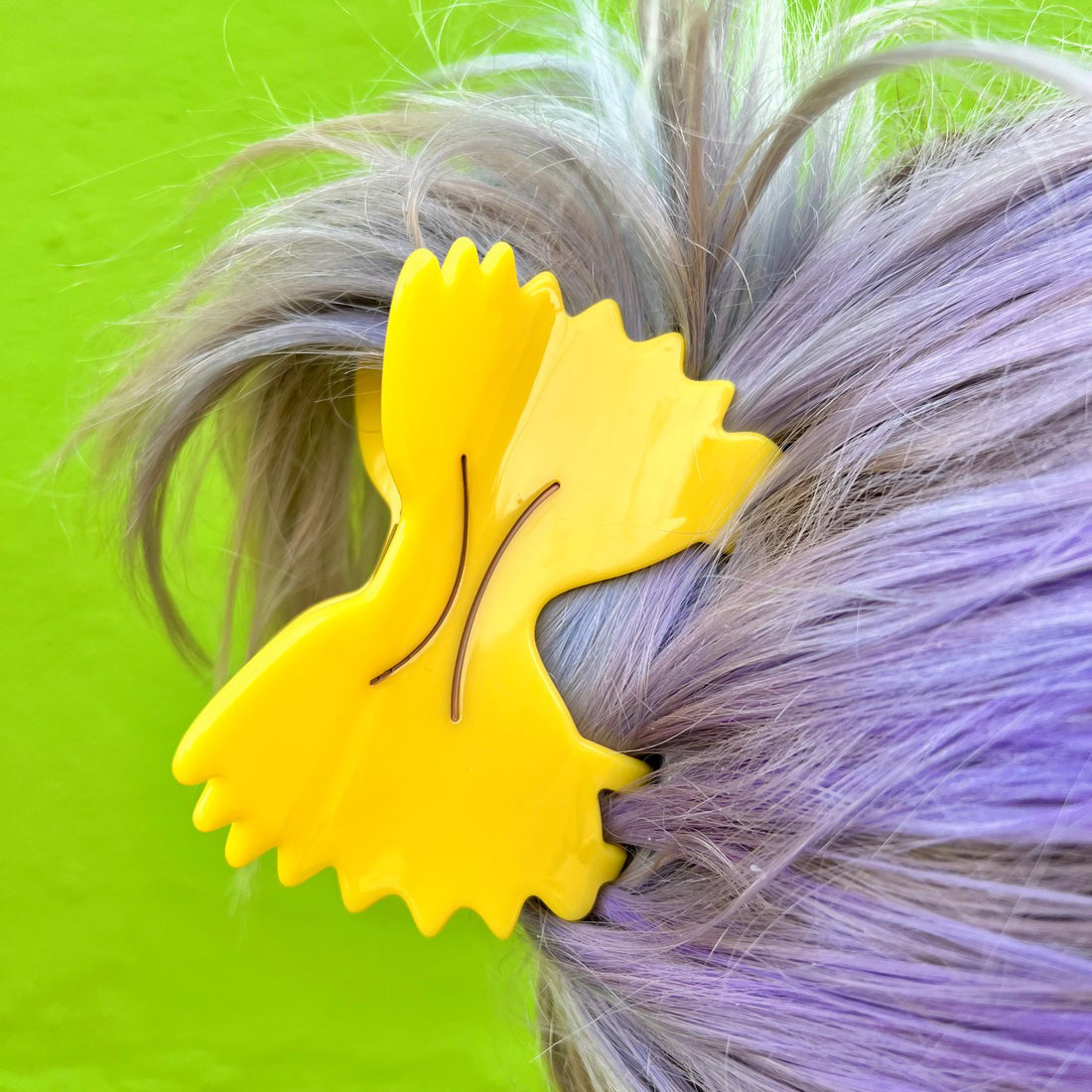 Farfalle Pasta Hair Claw on a person with multicolored hair against a green background