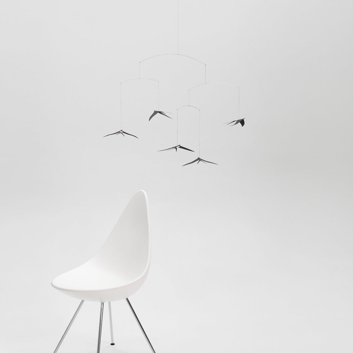 White chair with a mobile on a white background