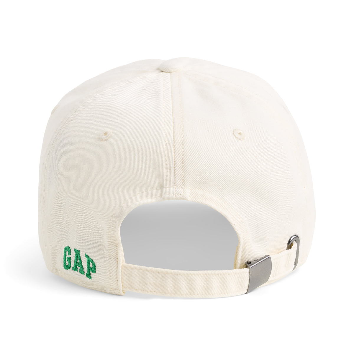 The back of a cream-colored cotton baseball cap with green 'GAP' embroidery on the side and an adjustable strap with a silver metal buckle.
