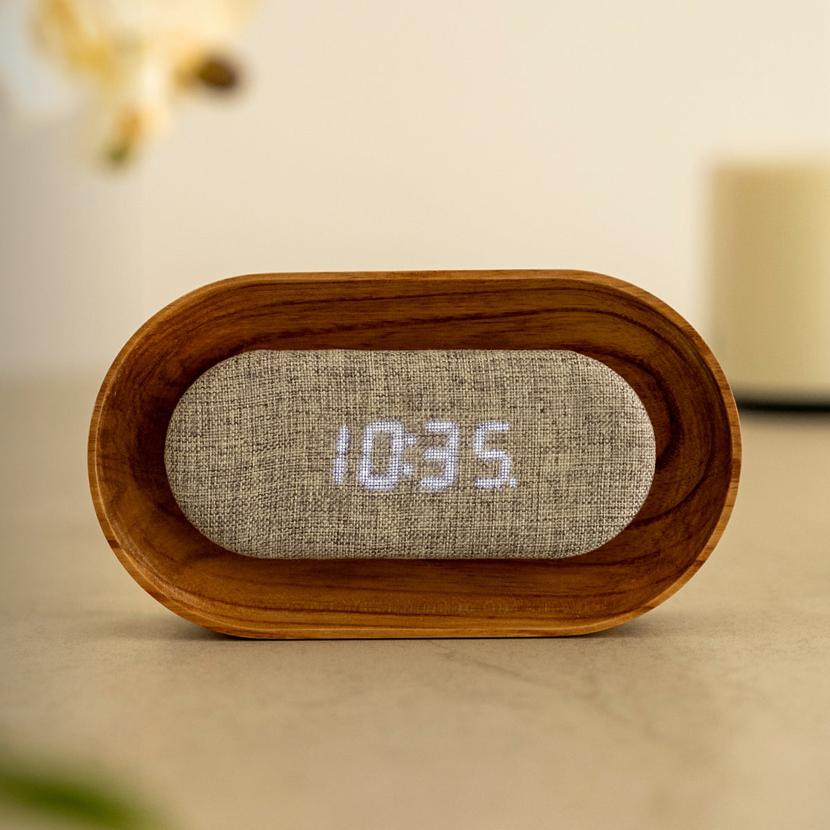 Wooden clock with digital display on a blurred background