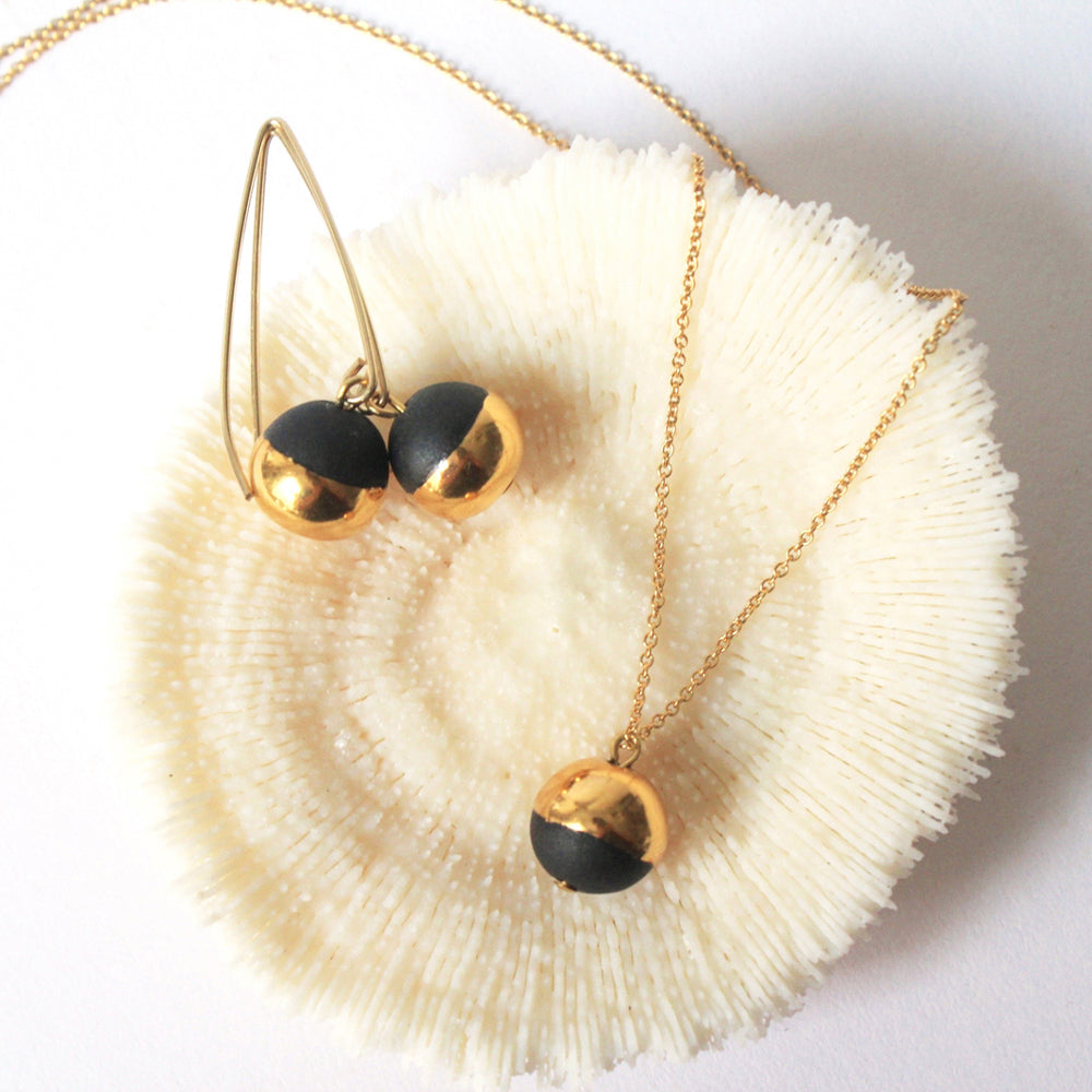 Earrings and necklace on fluffy object.