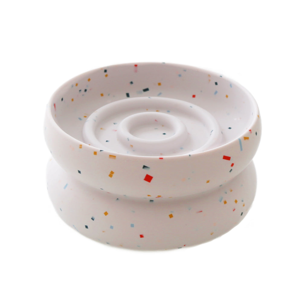 White bowl with colorful speckles on a white background
