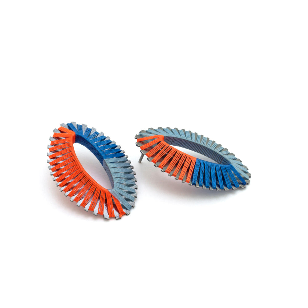 Pair of earrings with coral and blue threaded design on a white background
