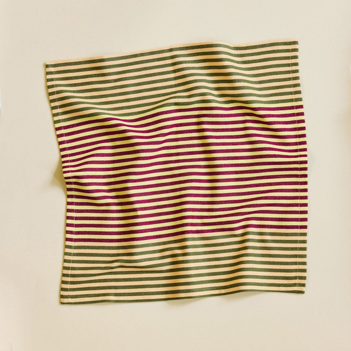 Striped fabric with green and purple lines on a beige background