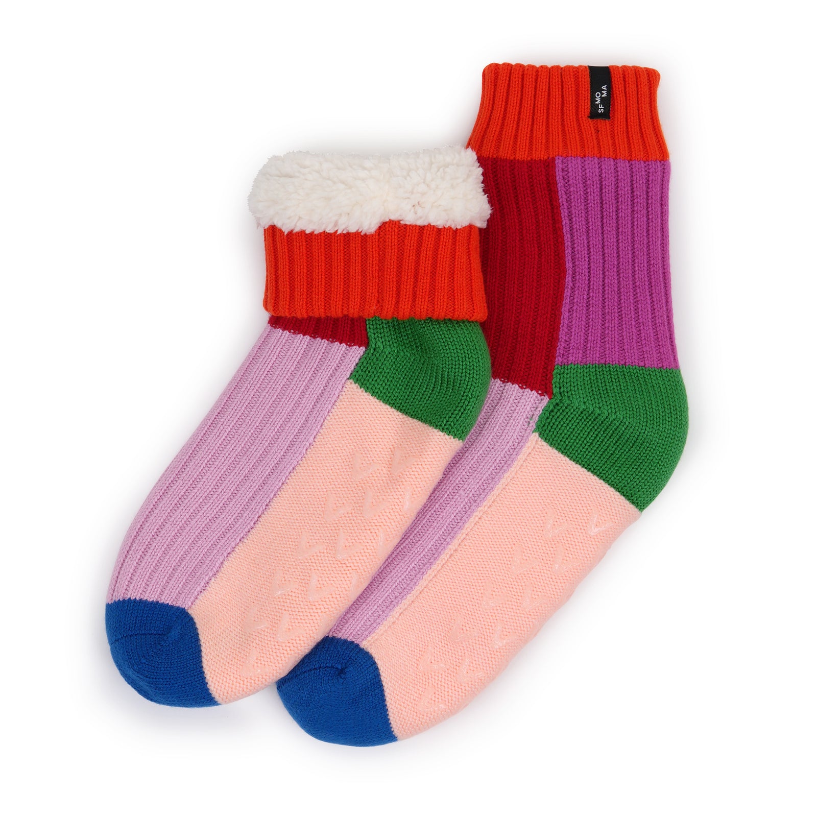 A pair of multicolor knit crew socks with a white sherpa lining at the top, featuring color-blocked sections of red, purple, pink, green, and blue on a white background.