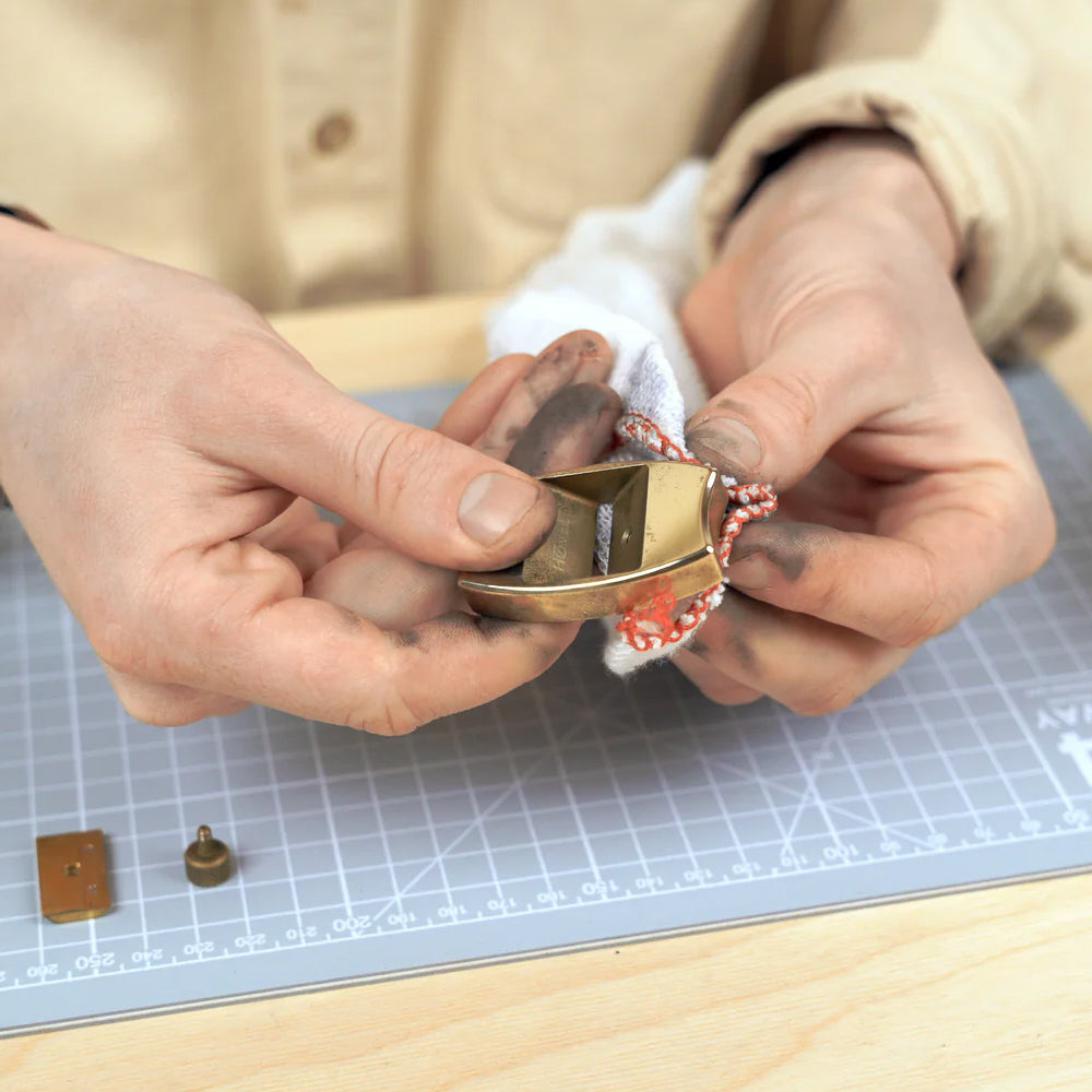 Person working on a sharpener with a wooden surface and grid mat in the background