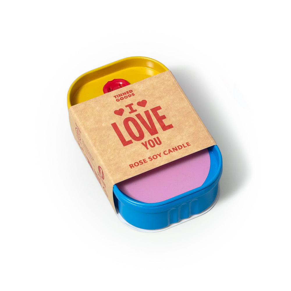 Candle in a blue container with a pink candle inside, wrapped in brown paper with 'I ❤️ LOVE YOU' text on a white background.