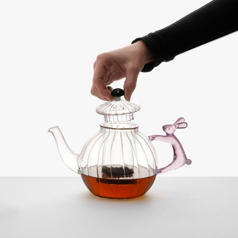 Model opening top of teapot.