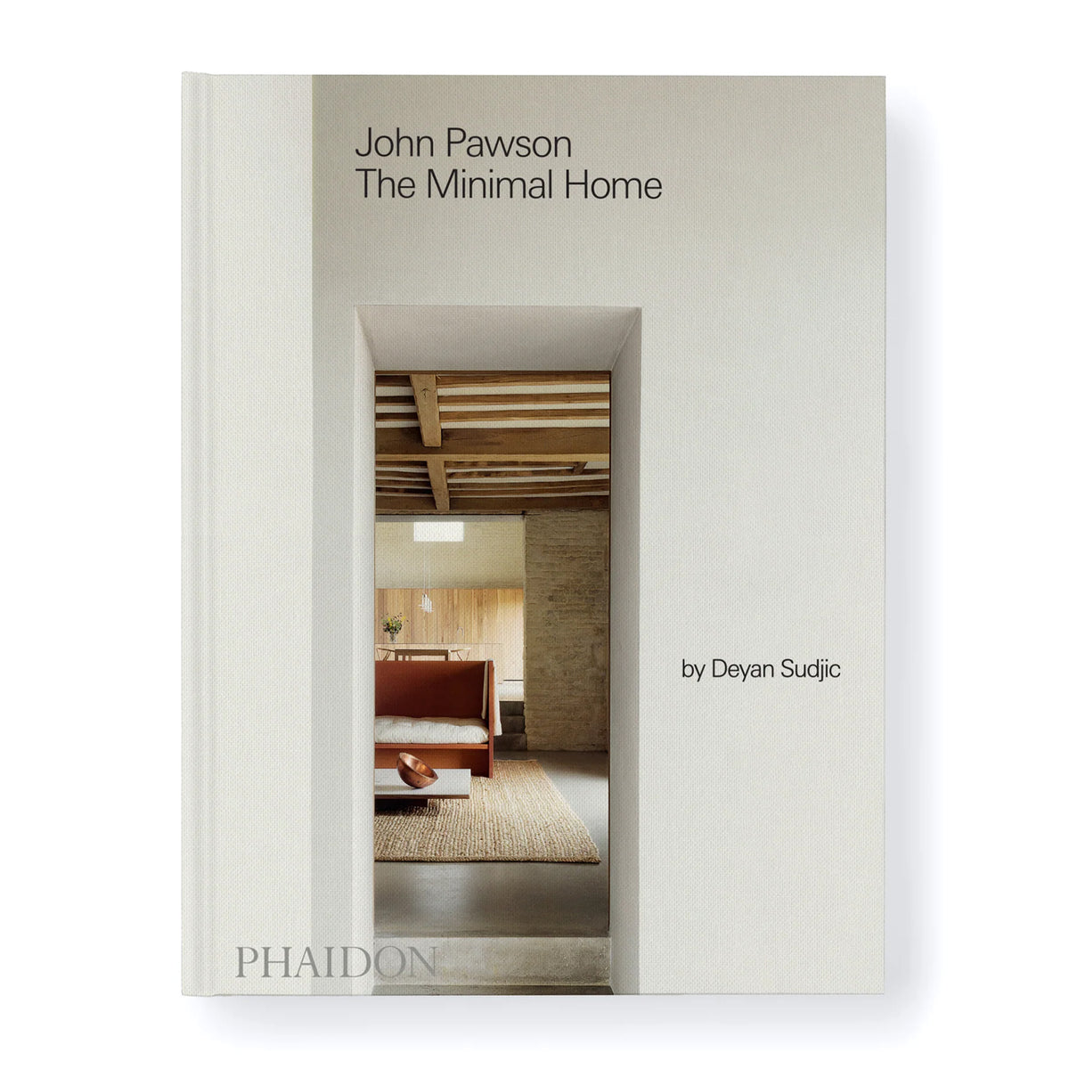 The book cover of 'John Pawson The Minimal Home' by Deyan Sudjc, published by Phaidon. The cover is a warm off-white/cream color with a central architectural photograph showing a minimalist interior with a wooden bed and a woven rug.