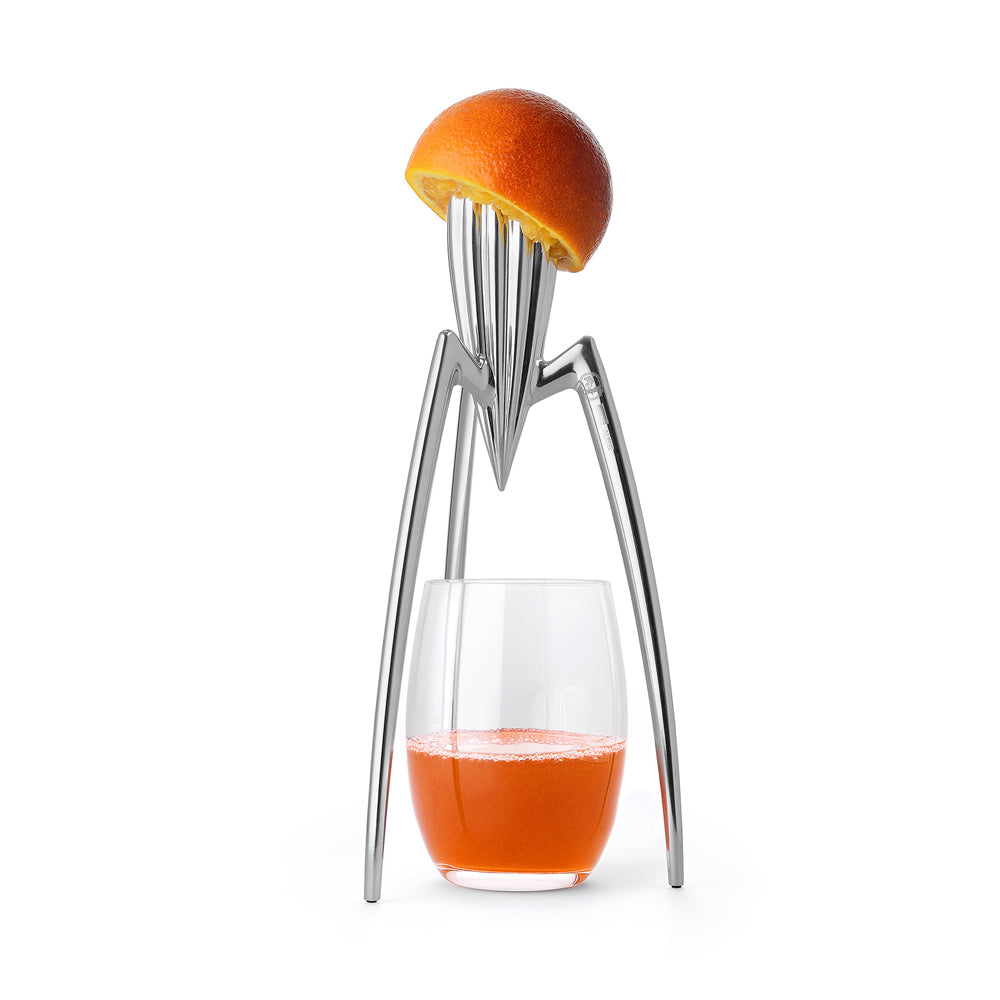 Juice press with an orange and a glass of orange juice on a white background