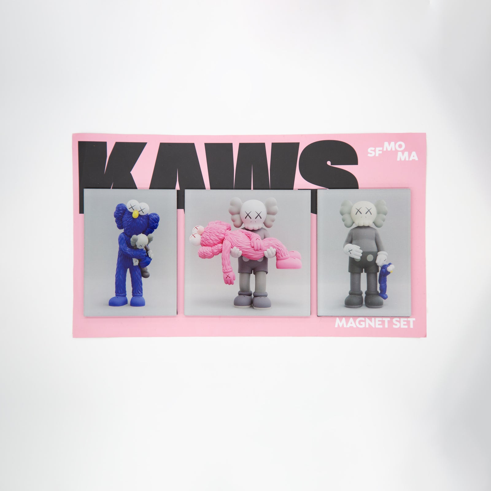 Three KAWS sculptures on gray backgrounds