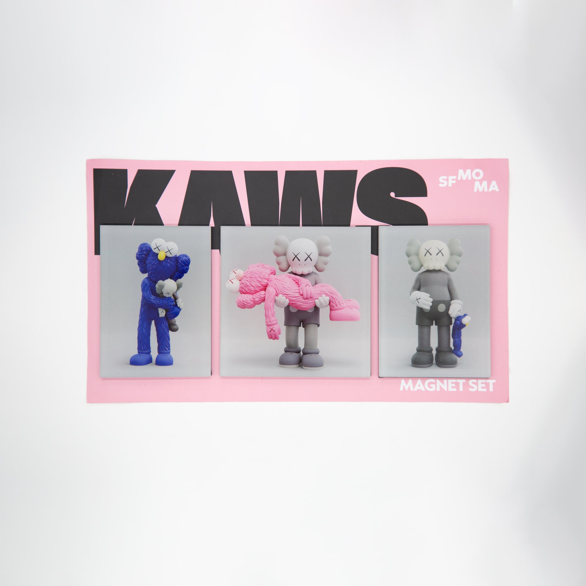 Three KAWS sculptures on gray backgrounds