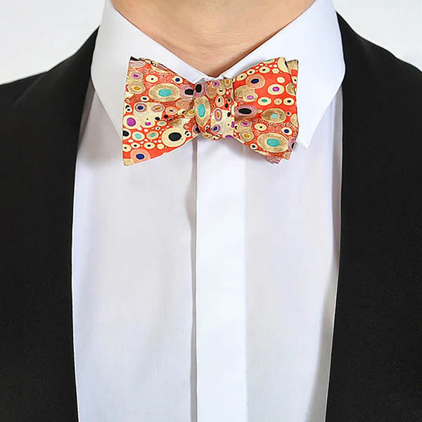 Person wearing a colorful bow tie with a black suit and white shirt.