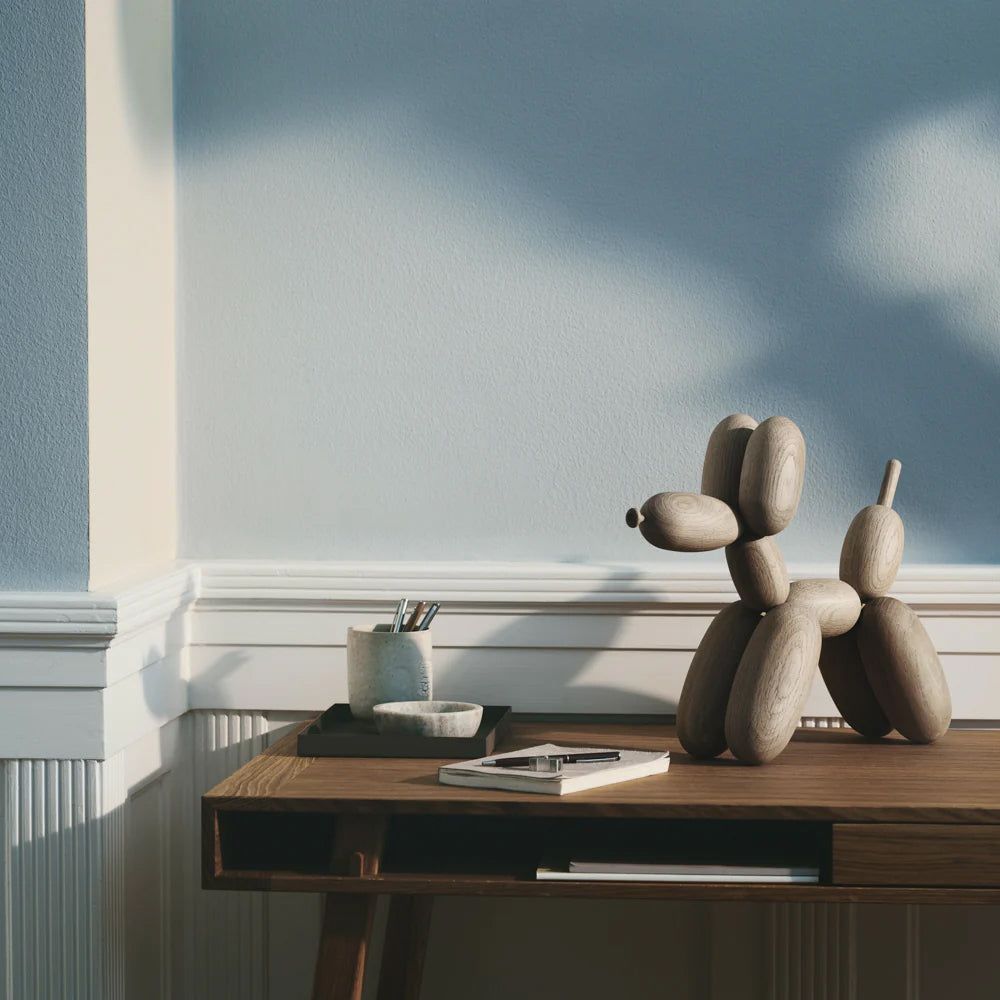 Wooden balloon dog sculpture on a white background