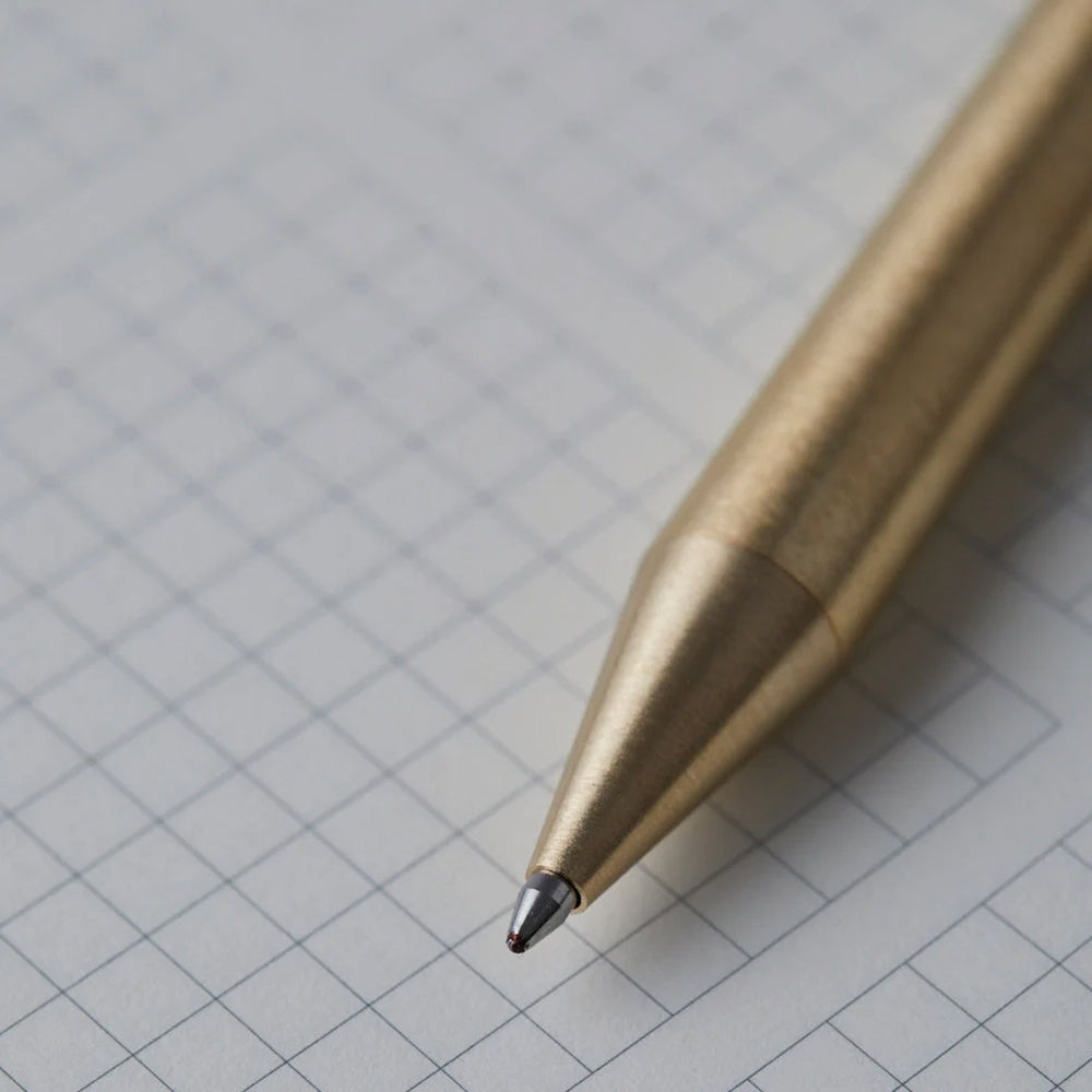 Close-up brass pen on a grid background