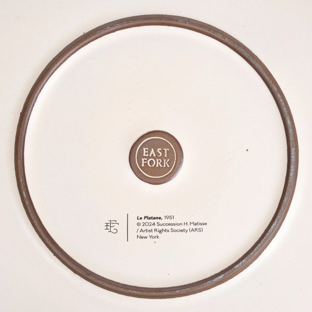 Back view of plate, showing the brand 'EAST FORK' in a circular brown logo on a white background, with release details for 'Le Platane, 1951' printed below.
