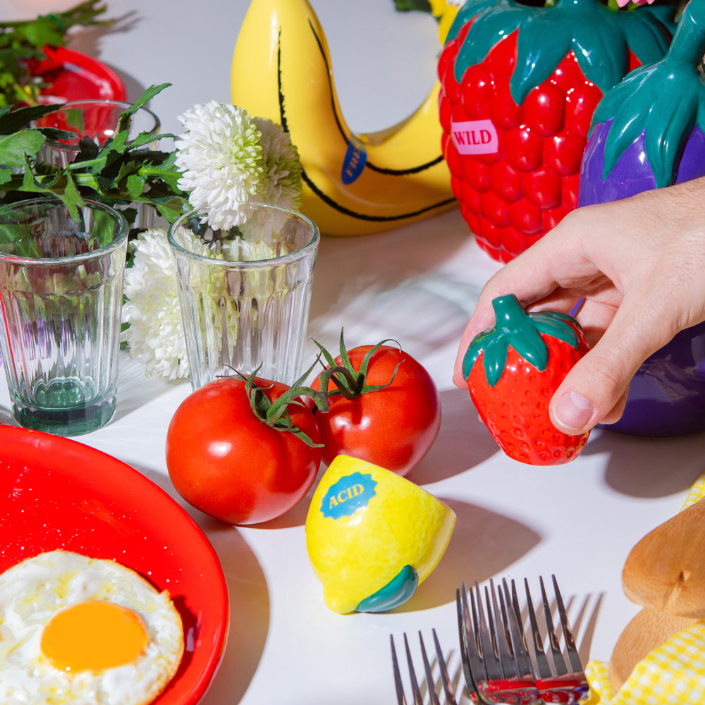 Model holding berry shaker on table.