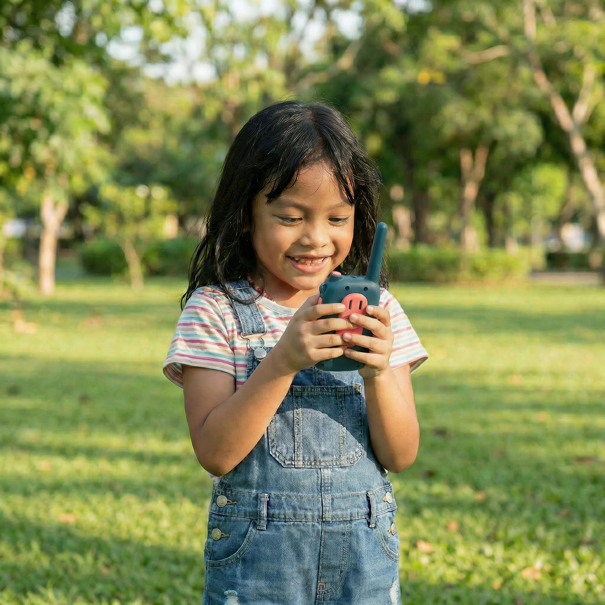 Child holding teal walk talkie.