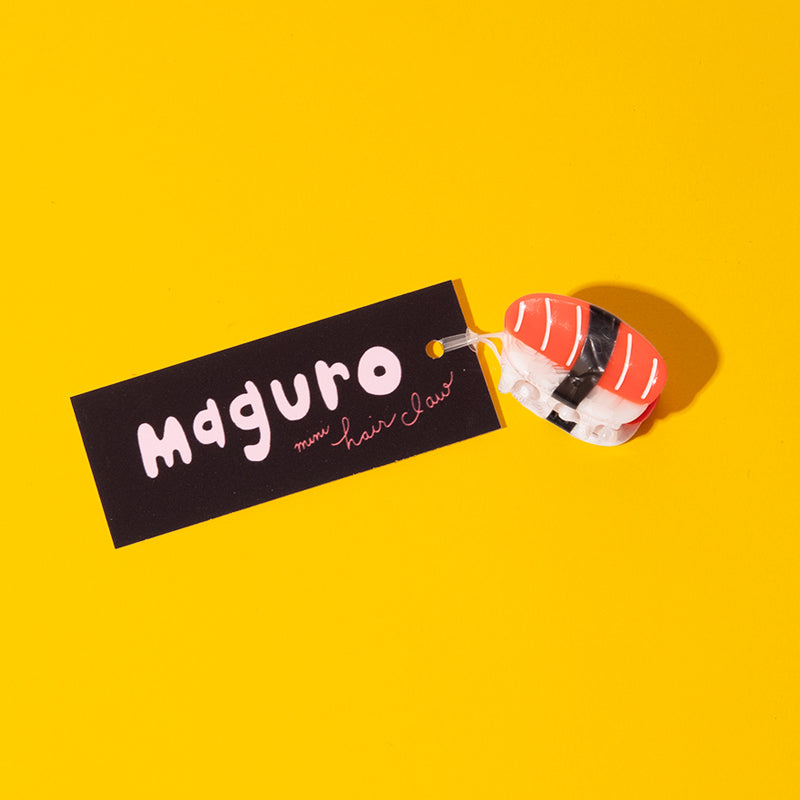 Maguro sushi-shaped hair clip on a yellow background with 'Maguro' label