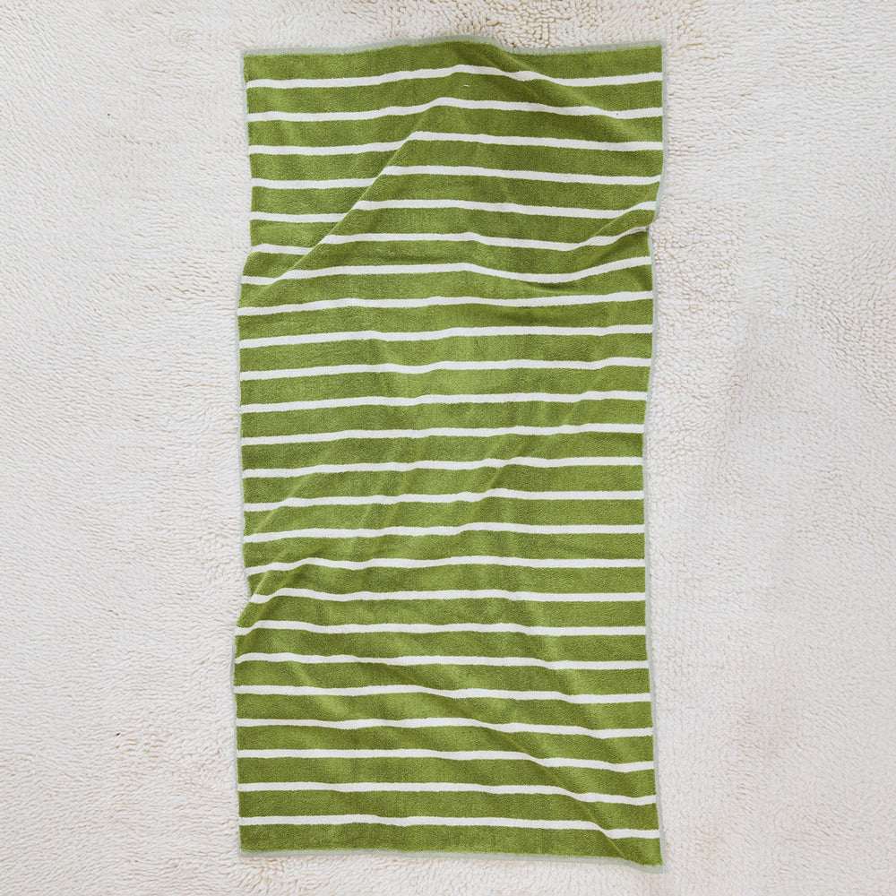 Folded green and white striped towel on a white background