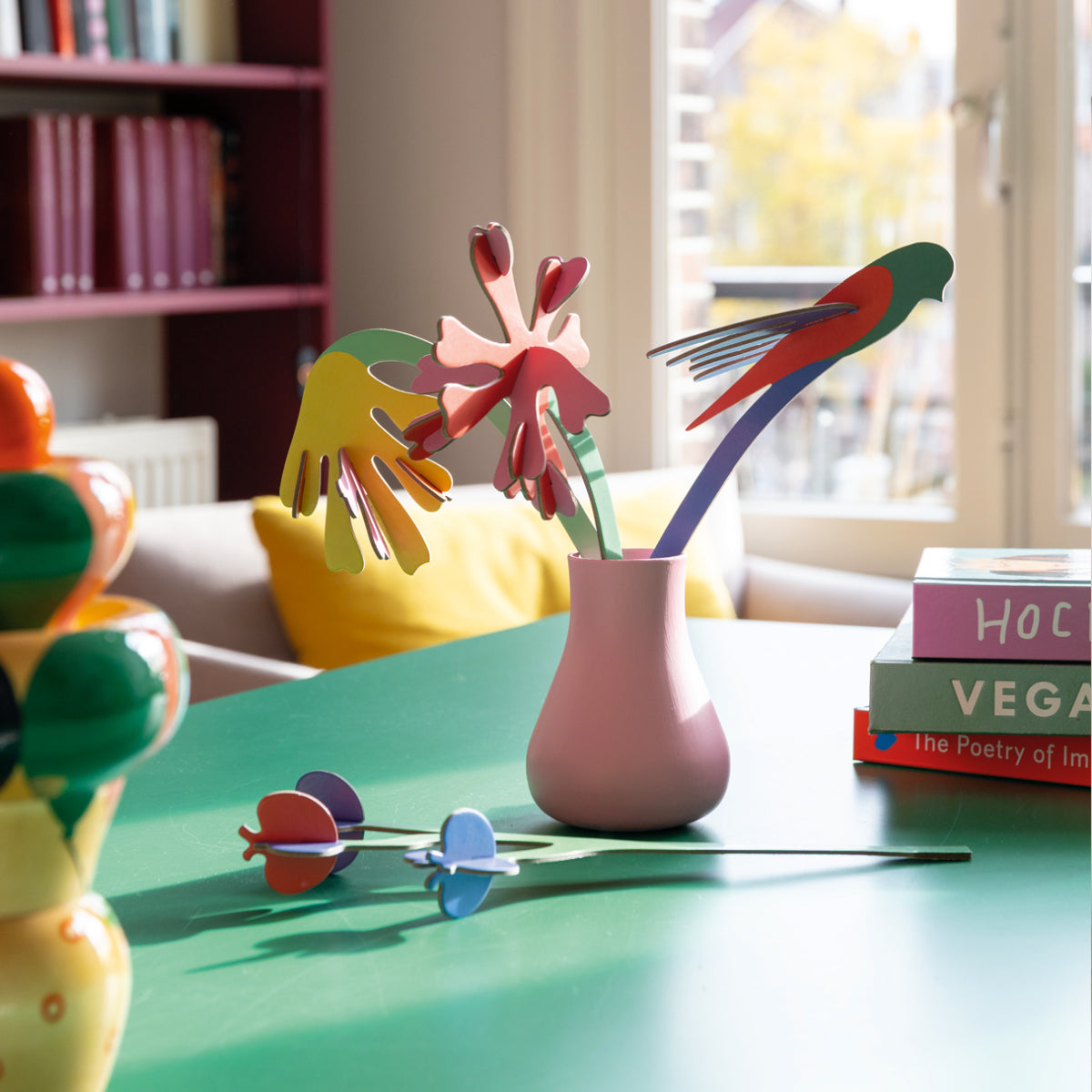 Colorful abstract floral bouquet on a table with books in the background