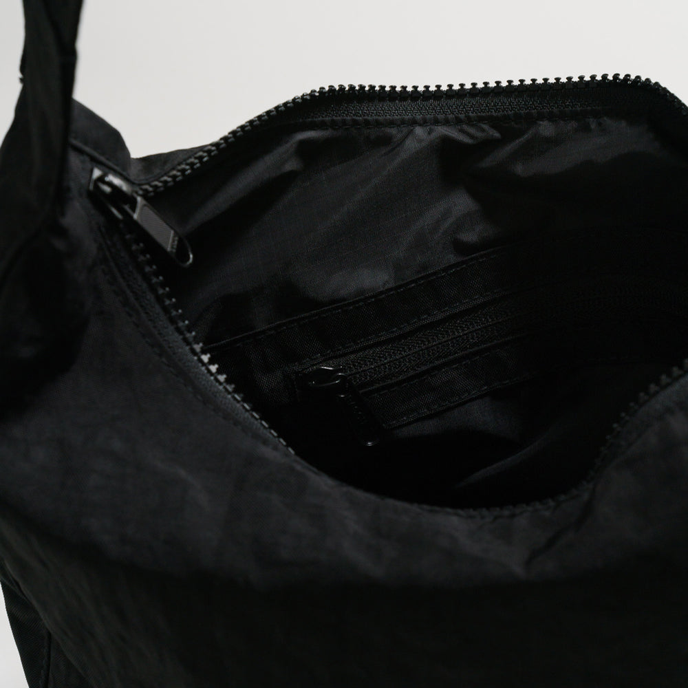 Close-up of a black bag with a zipper on a light gray background