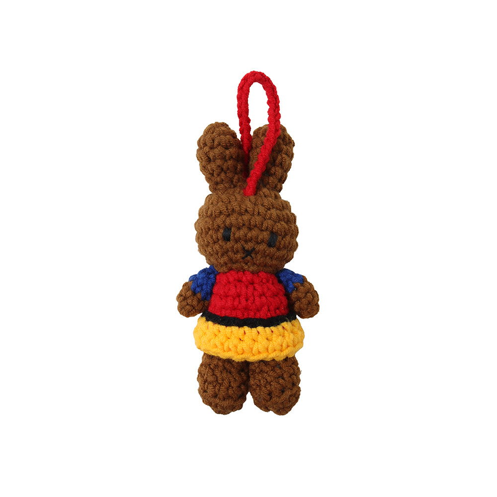 Hand-crocheted, multicolored, cotton ornament in the shape of a stylized character, predominantly brown with red, yellow, and blue accents.