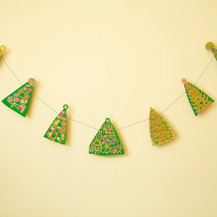Decorative paper trees with floral patterns on a string against a yellow background