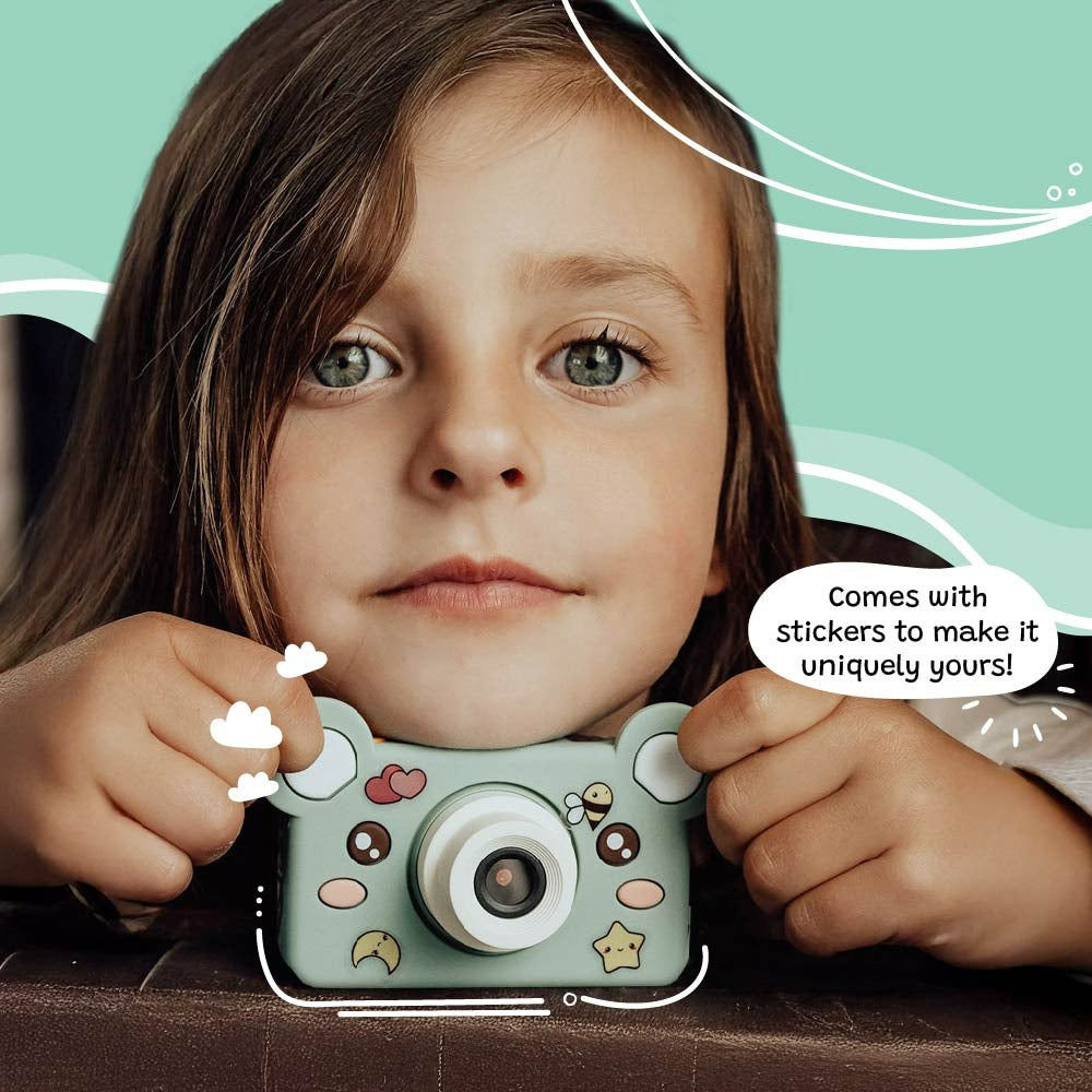 Child holding a toy camera with stickers on a teal background