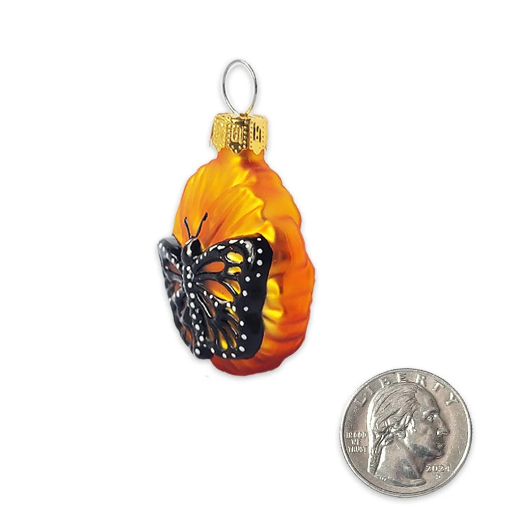 A single flower-shaped Christmas ornament with yellow and orange petals, a gold cap, and a hanging loop, shown on a plain white background.