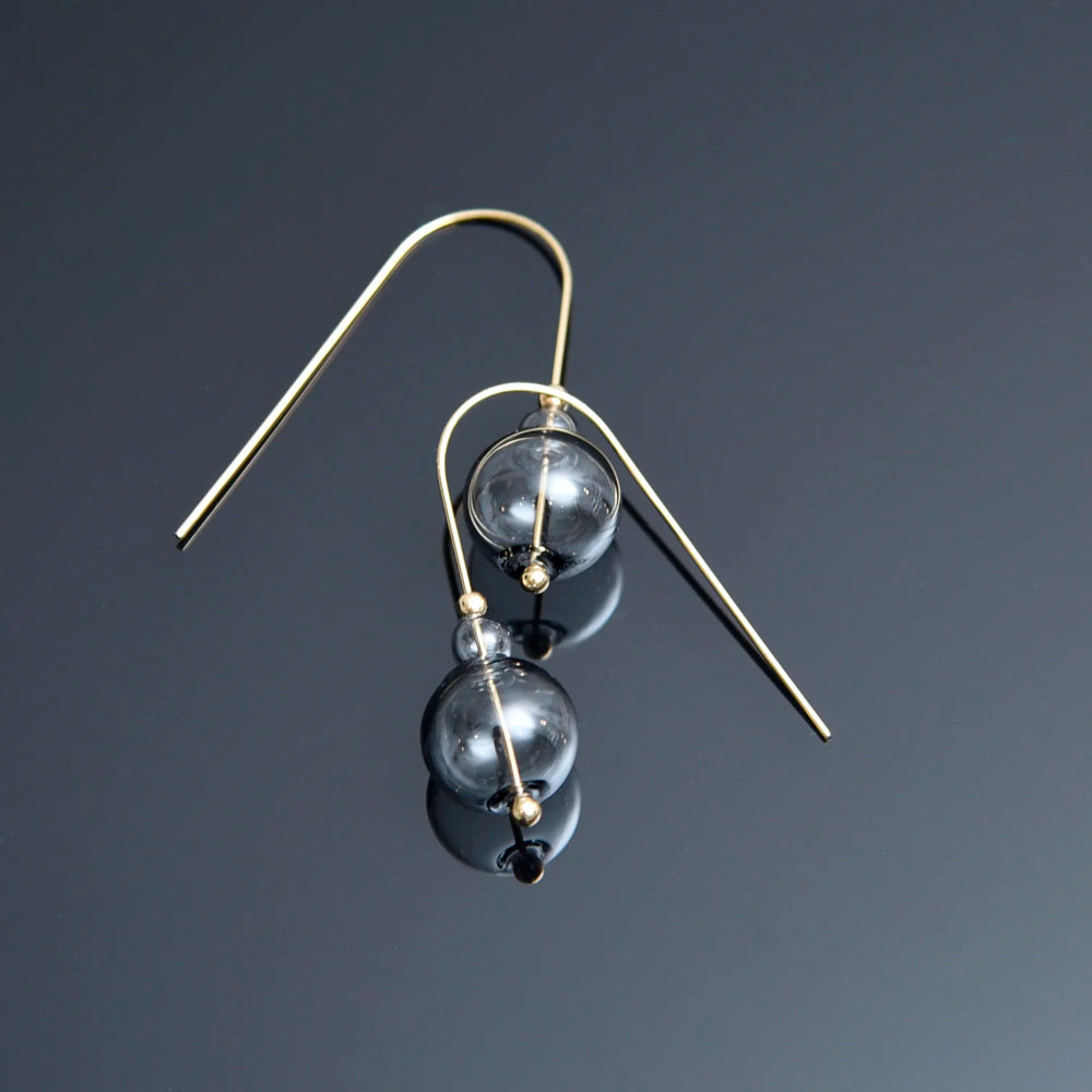 Pair of earrings with glass beads on a dark background