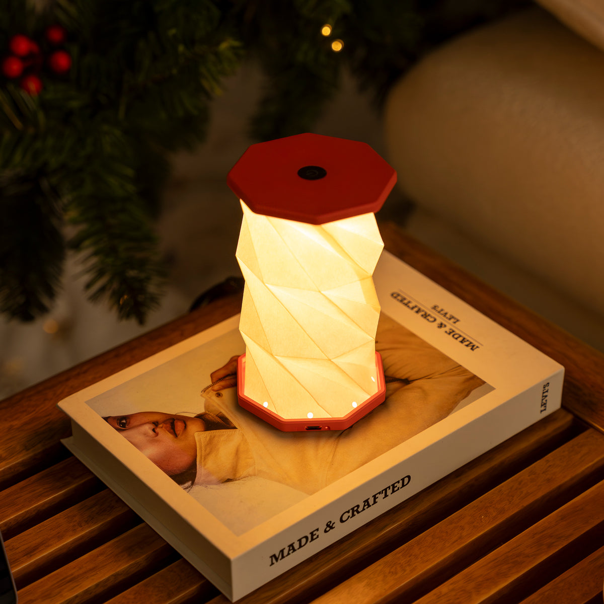 Folding lantern on a book with a blurred Christmas tree in the background