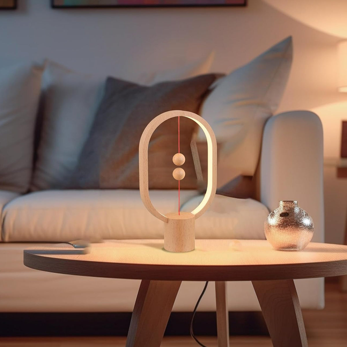 Balancing act lamp on a table with a blurred sofa and cushions in the background