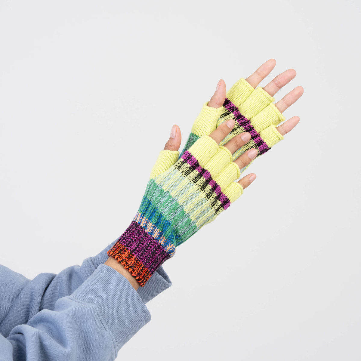 A pair of multicolor striped knit fingerless gloves on a plain white background, showing both the front and back views.