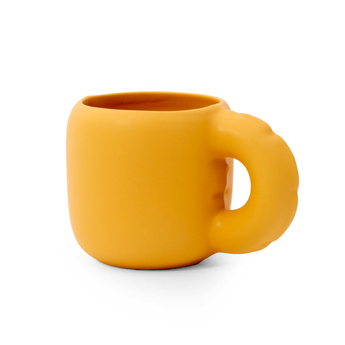 A matte mustard yellow silicone mug with a unique sculpted handle, shown on a clean white background.
