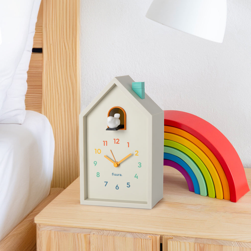 House-shaped clock with a bird design on a white background