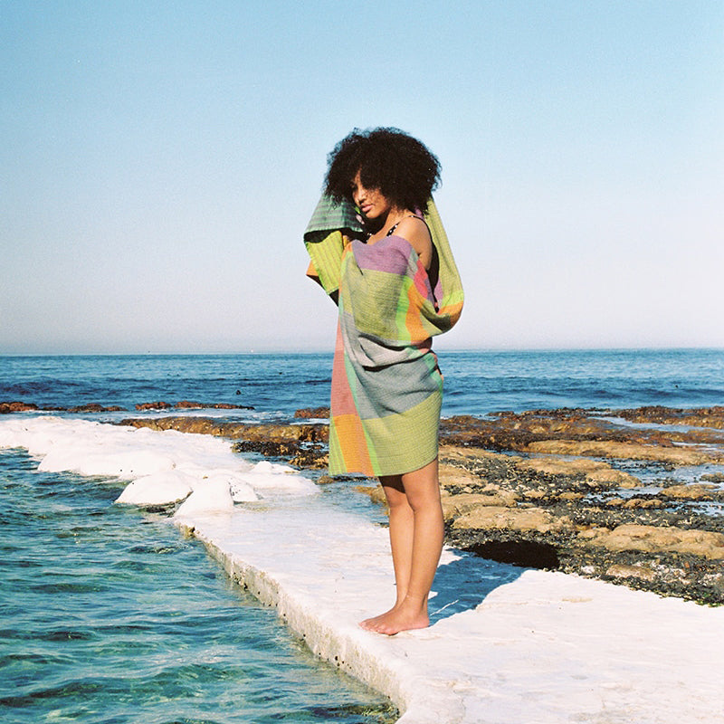 Model wearing towel at the beach.