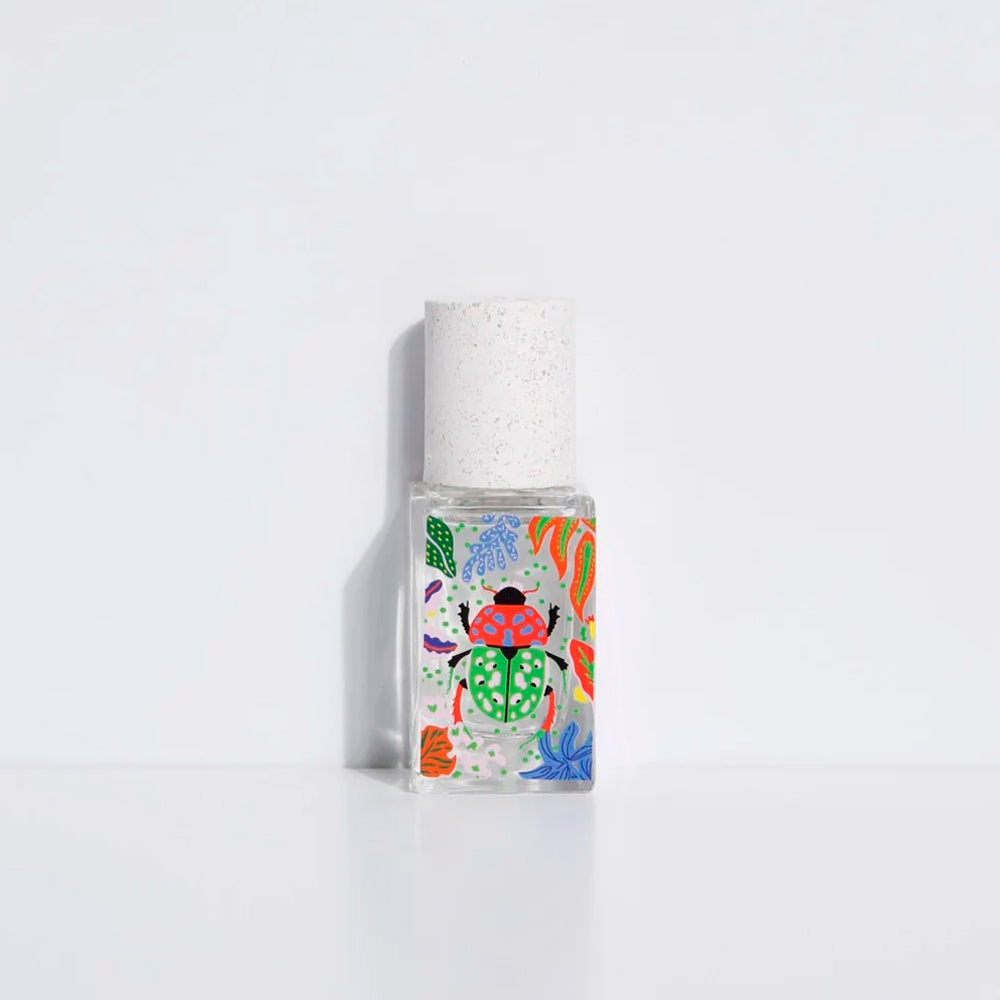 A clear rectangular bottle with a white textured cap, filled with a clear liquid and decorated with a colorful ladybug illustration and botanical patterns, set against a plain white background.