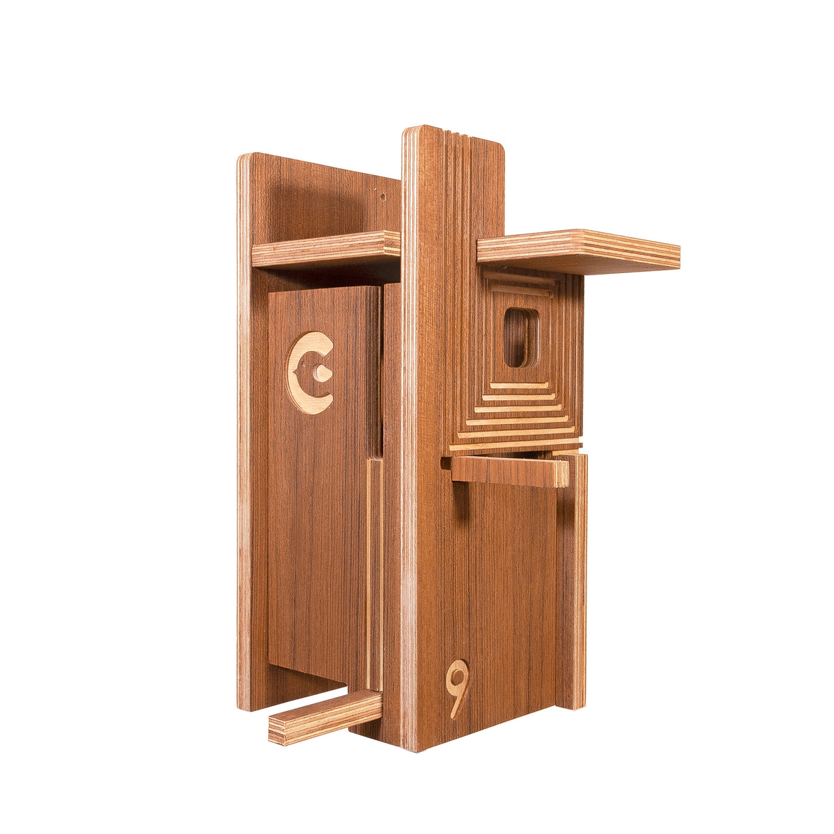A wooden birdhouse-style decorative object with layered shelves, a recessed window, and engraved numbers and symbols, shown on a plain white background.