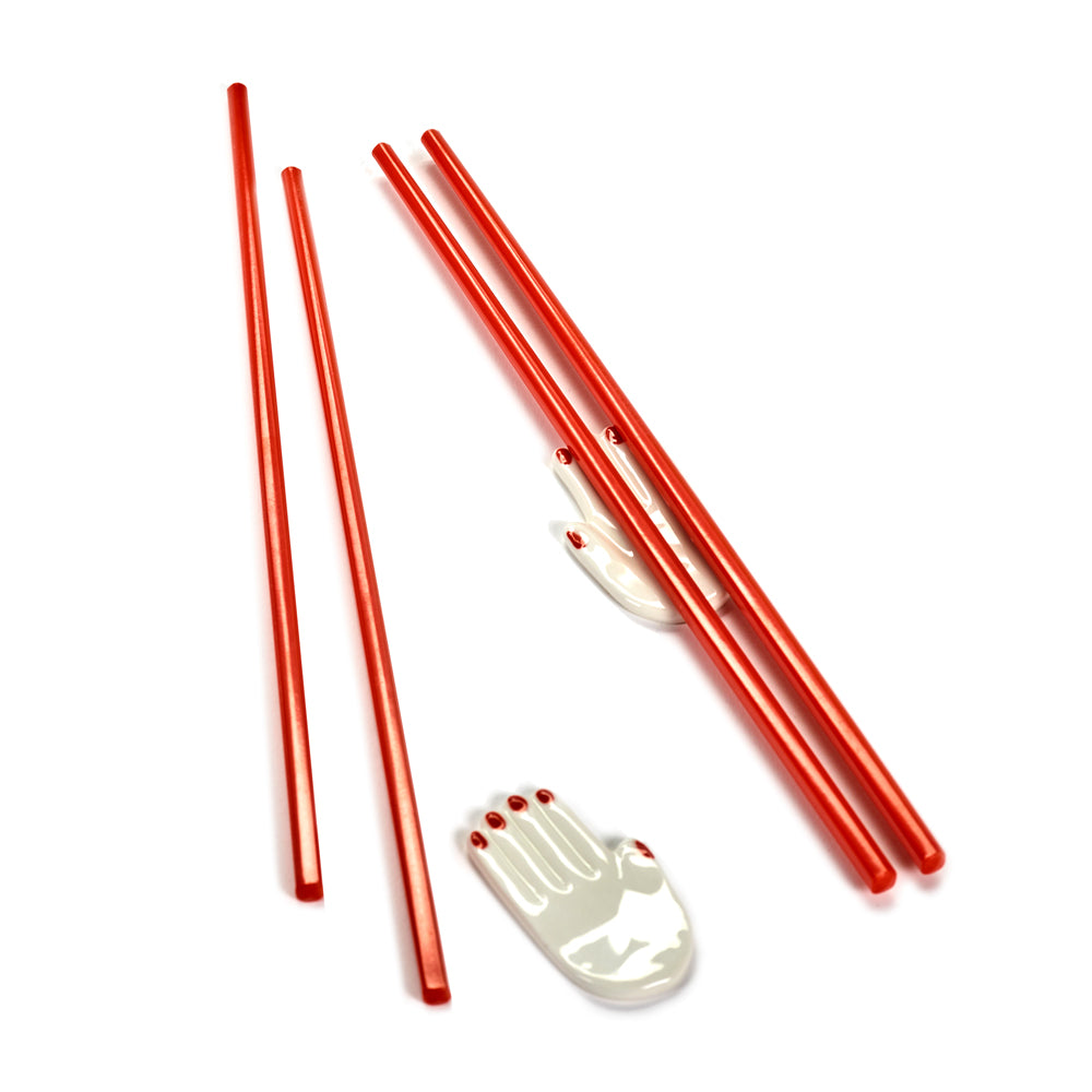 Red chopsticks with a white hand-shaped holder on a white background