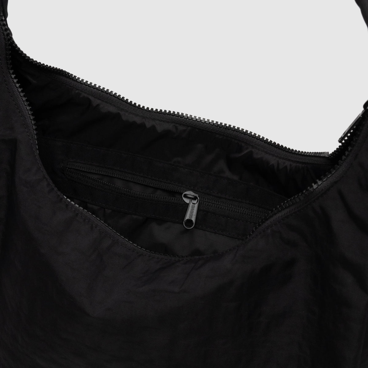 Close-up of a black bag with a zipper detail on a white background