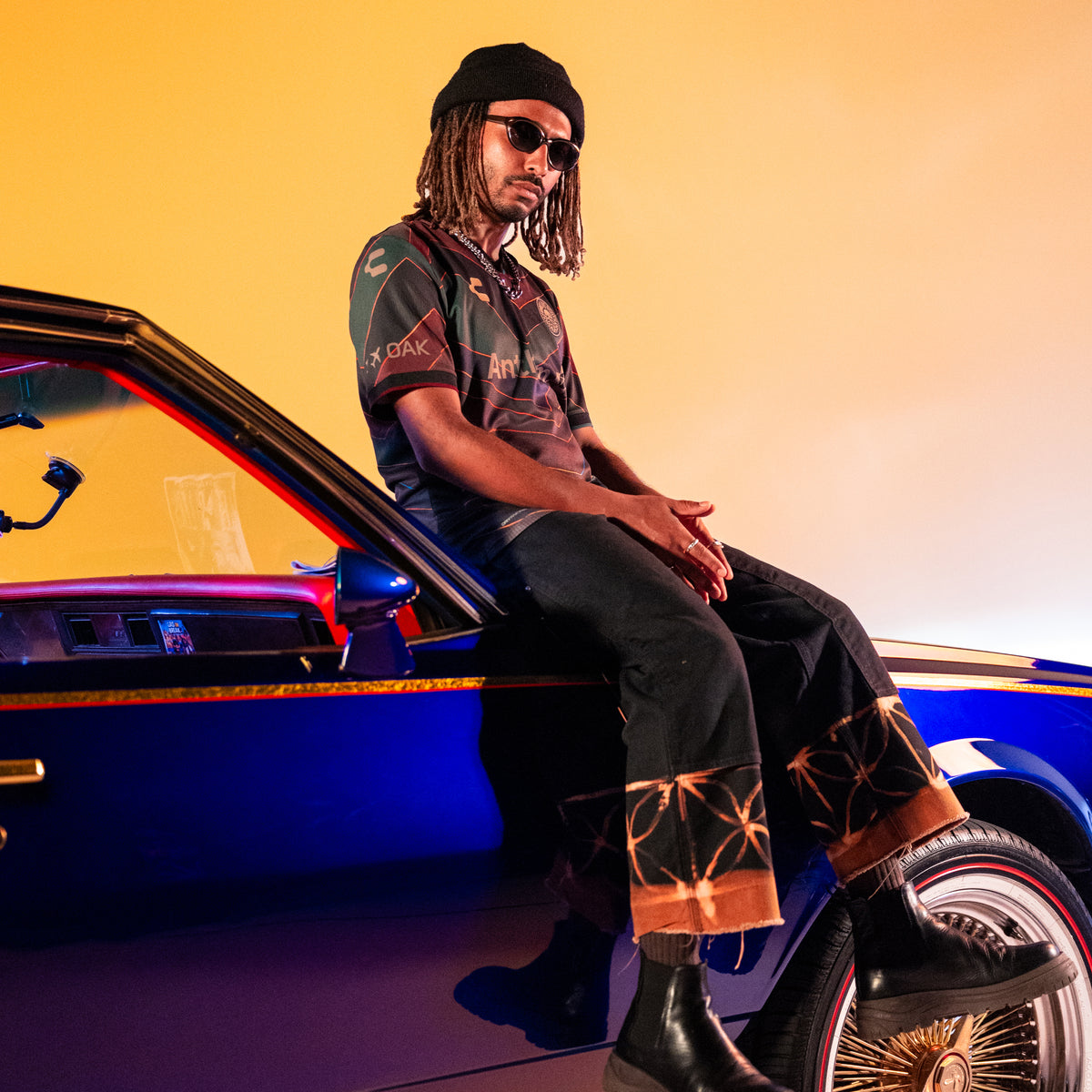 XXXL Oakland Roots SC x SFMOMA Limited-Edition 2025 Jersey worn by Muzae sitting on a car