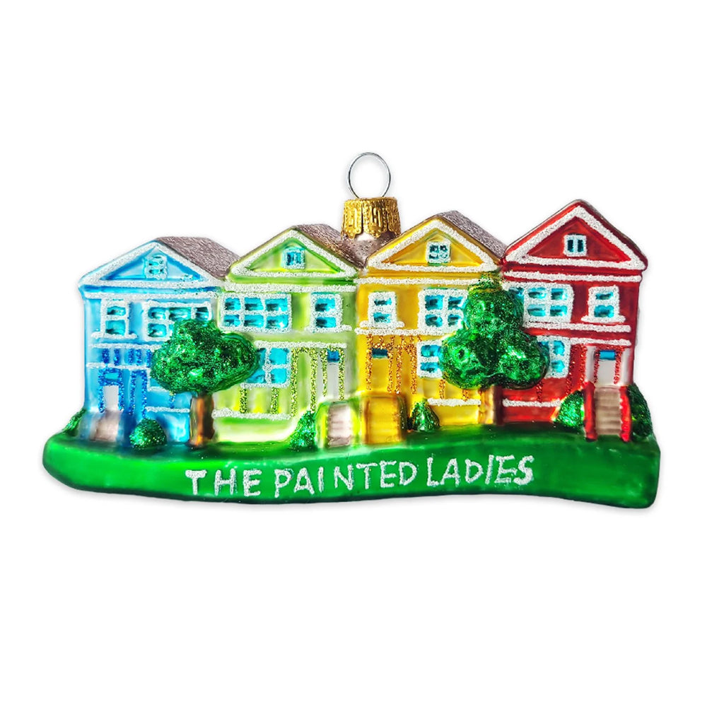A colorful Christmas ornament depicting the house from The Painted Ladies, featuring five vibrant, painted houses in blue, green, yellow, and red on a green base with the text 'THE PAINTED LADIES'.