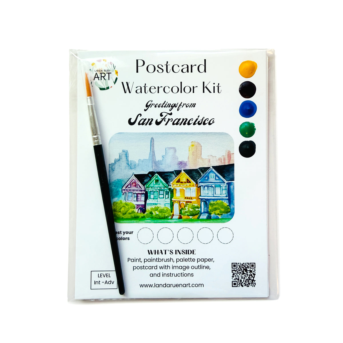 Postcard Watercolor Kit in its plastic packaging, featuring a paintbrush, a watercolor illustration of San Francisco houses and skyline, and a color palette on the front.