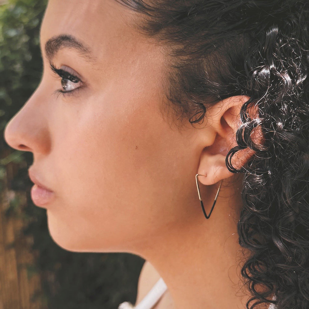 Close-up of a woman's profile with a geometric hoop earring.