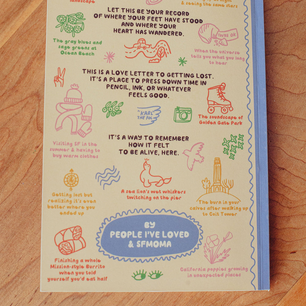 Notebook with colorful illustrations and text on a wooden surface