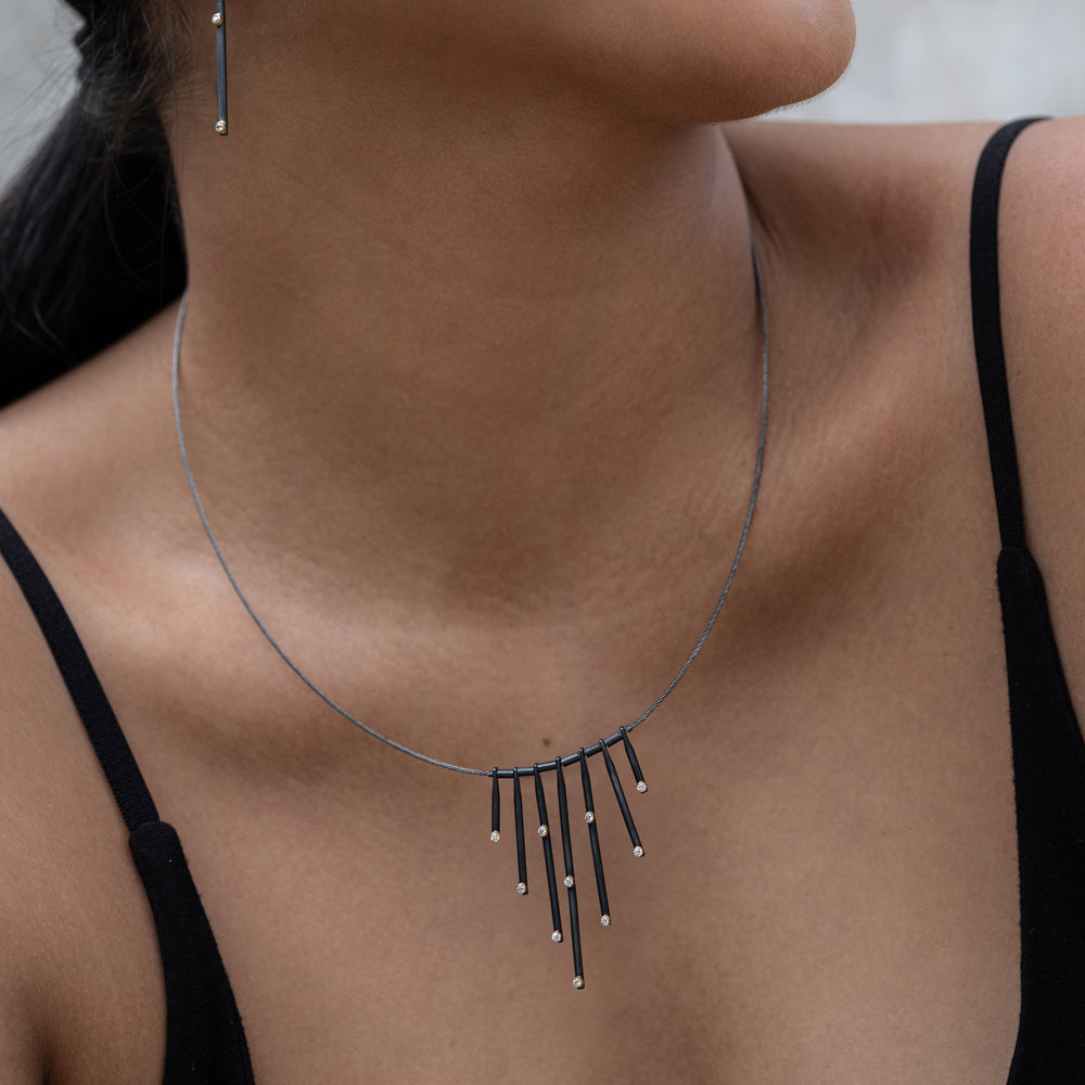 Necklace with dangling beads worn by a person